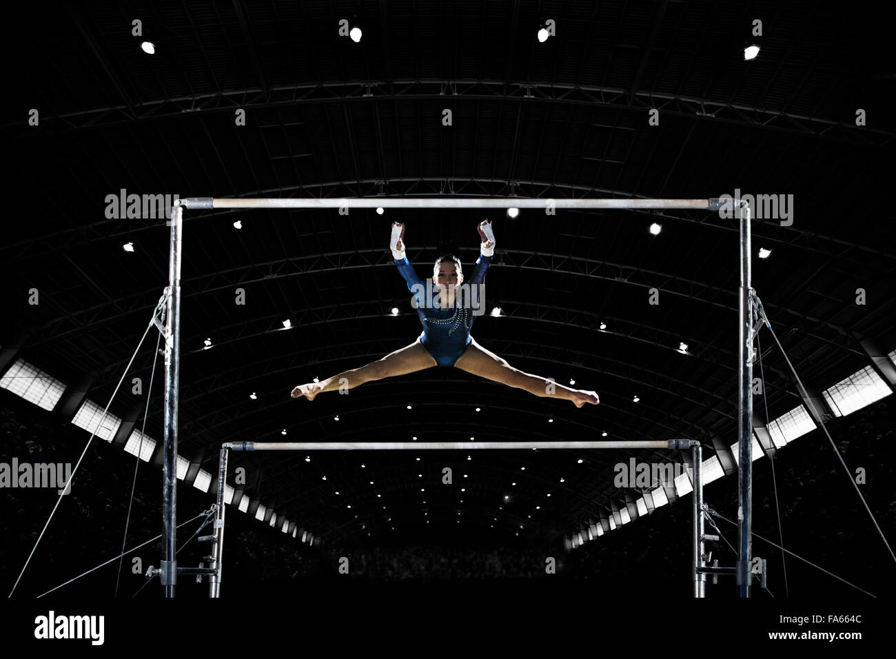 Une gymnaste, une jeune femme d'effectuer sur les barres parallèles, l'exécution, avec les jambes étendues. Banque D'Images