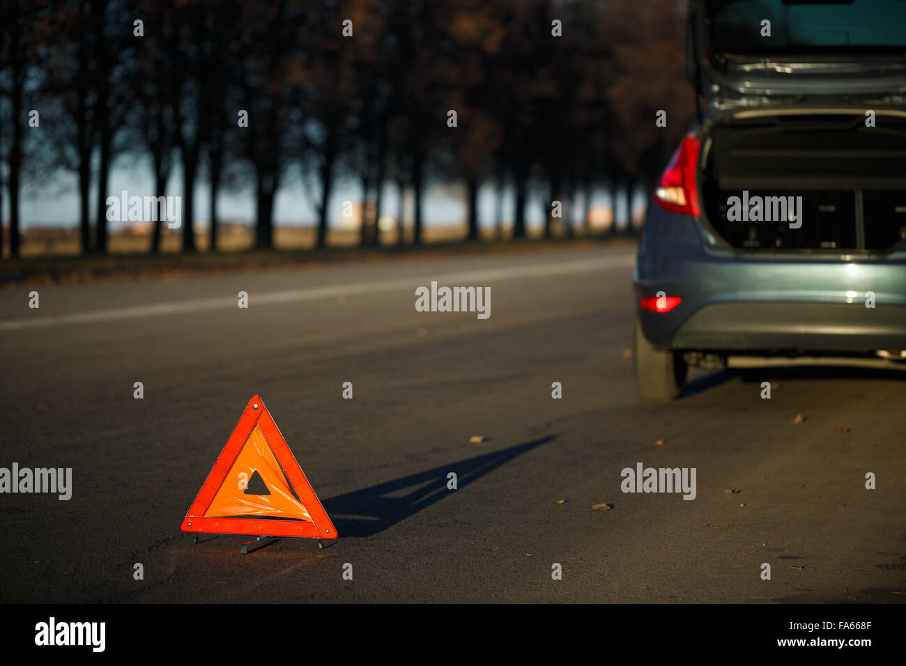 Triangle d'avertissement rouge avec une voiture en panne Banque D'Images
