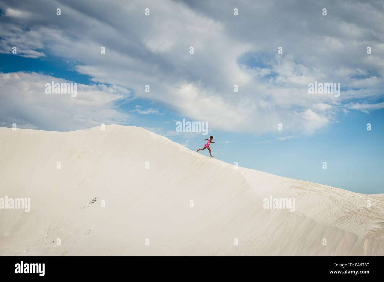 Fille courir vers le bas dune de sable, tête verte, Australie occidentale, Australie Banque D'Images