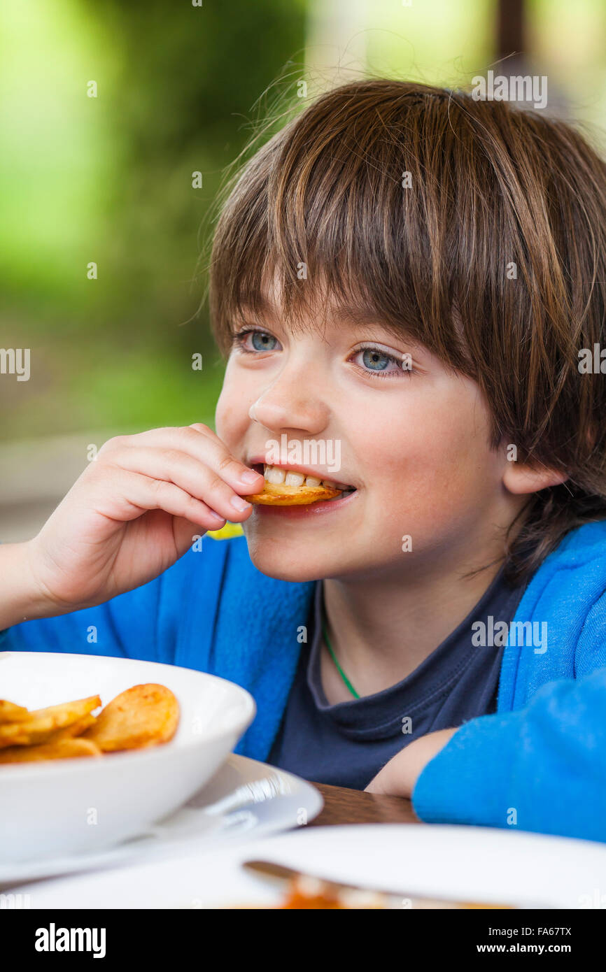 Portrait of a Boy eating French Fries Banque D'Images