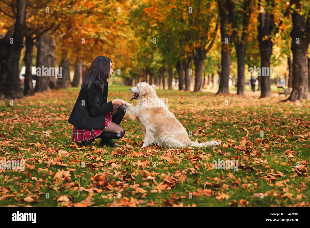 Girl sitting in park with her dog Banque D'Images
