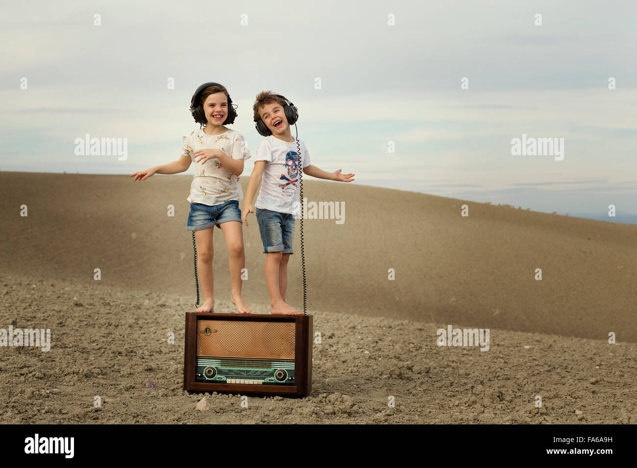 Garçon et fille dansant sur une vieille radio abandonnés Banque D'Images