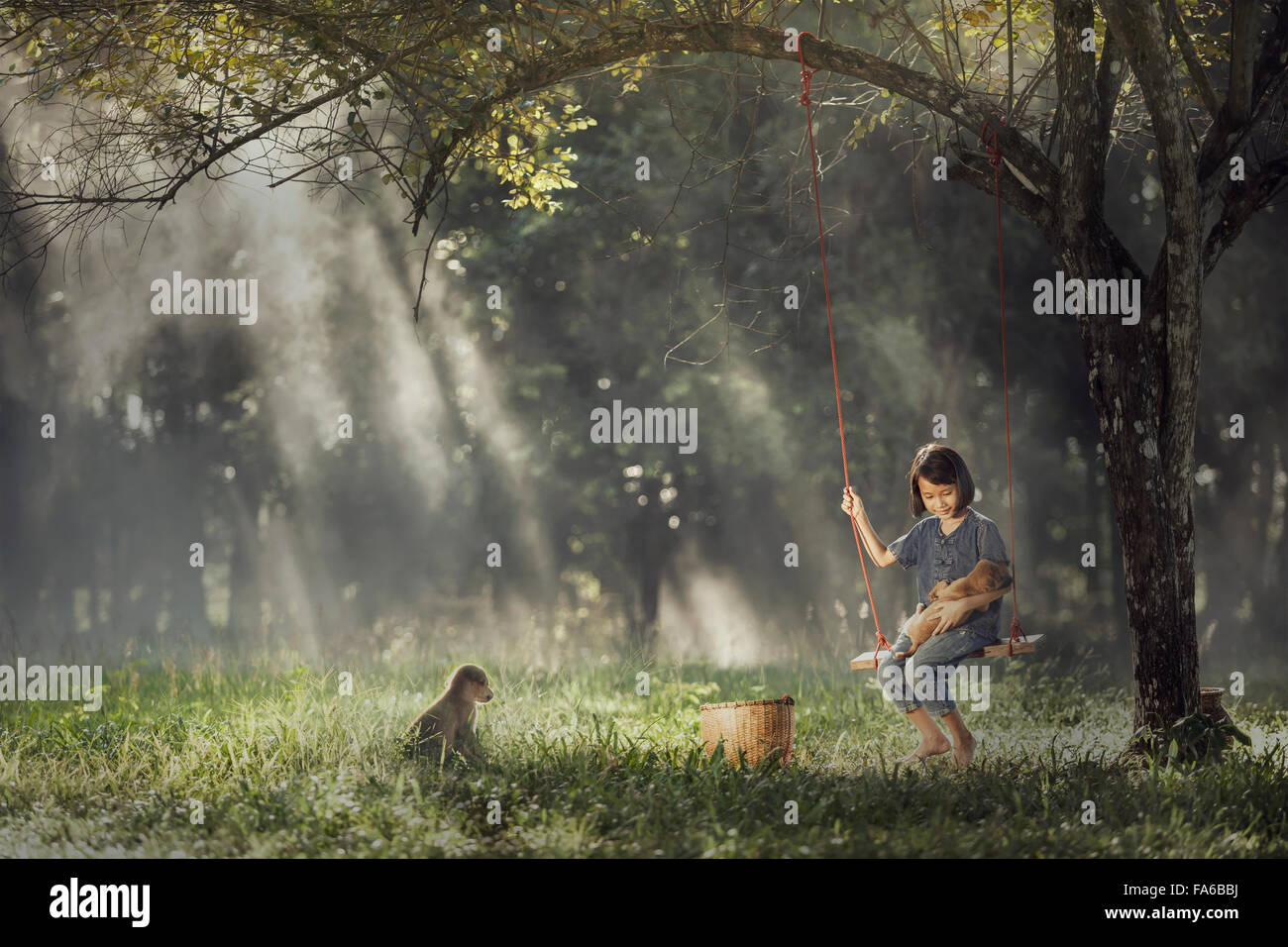 Girl sitting on swing avec son chien Banque D'Images
