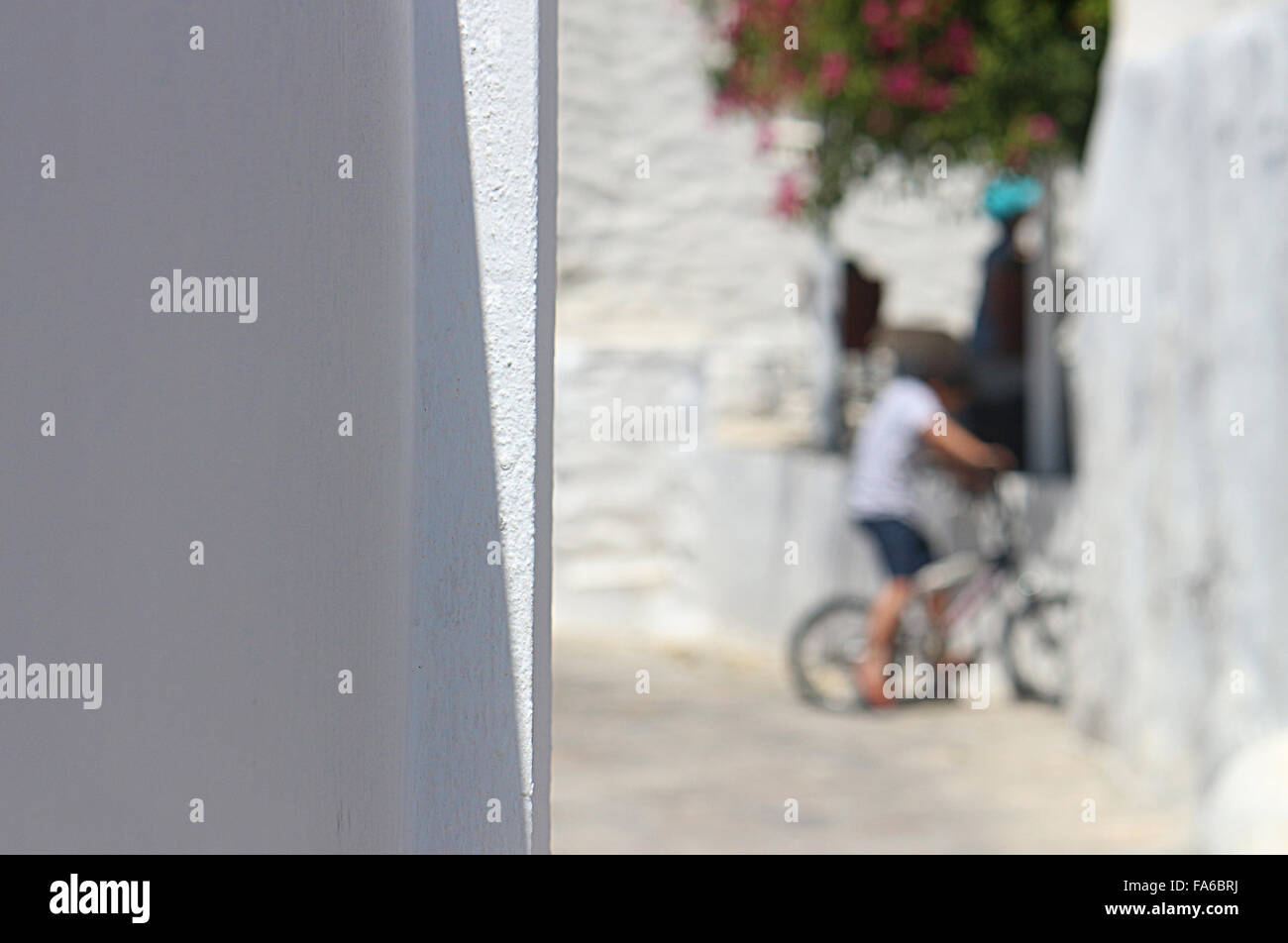 Méconnaissable garçon sur un vélo, l'île des Cyclades, Grèce Banque D'Images