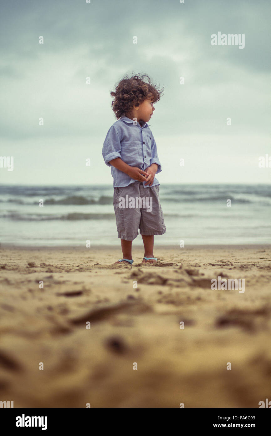 Garçon debout sur la plage Banque D'Images