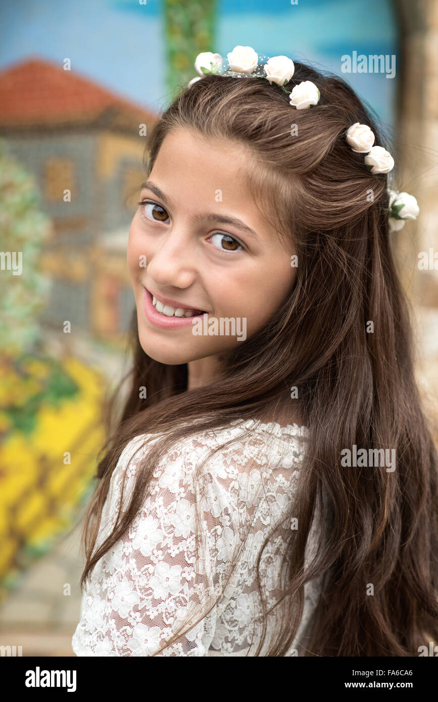 Smiling girl portant des fleurs dans ses cheveux Banque D'Images