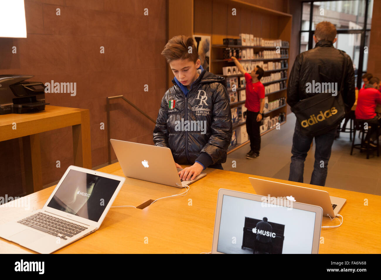 Un adolescent à l'aide d'un ordinateur portable Apple Macbook dans l'Apple store, Strasbourg, France Europe Banque D'Images