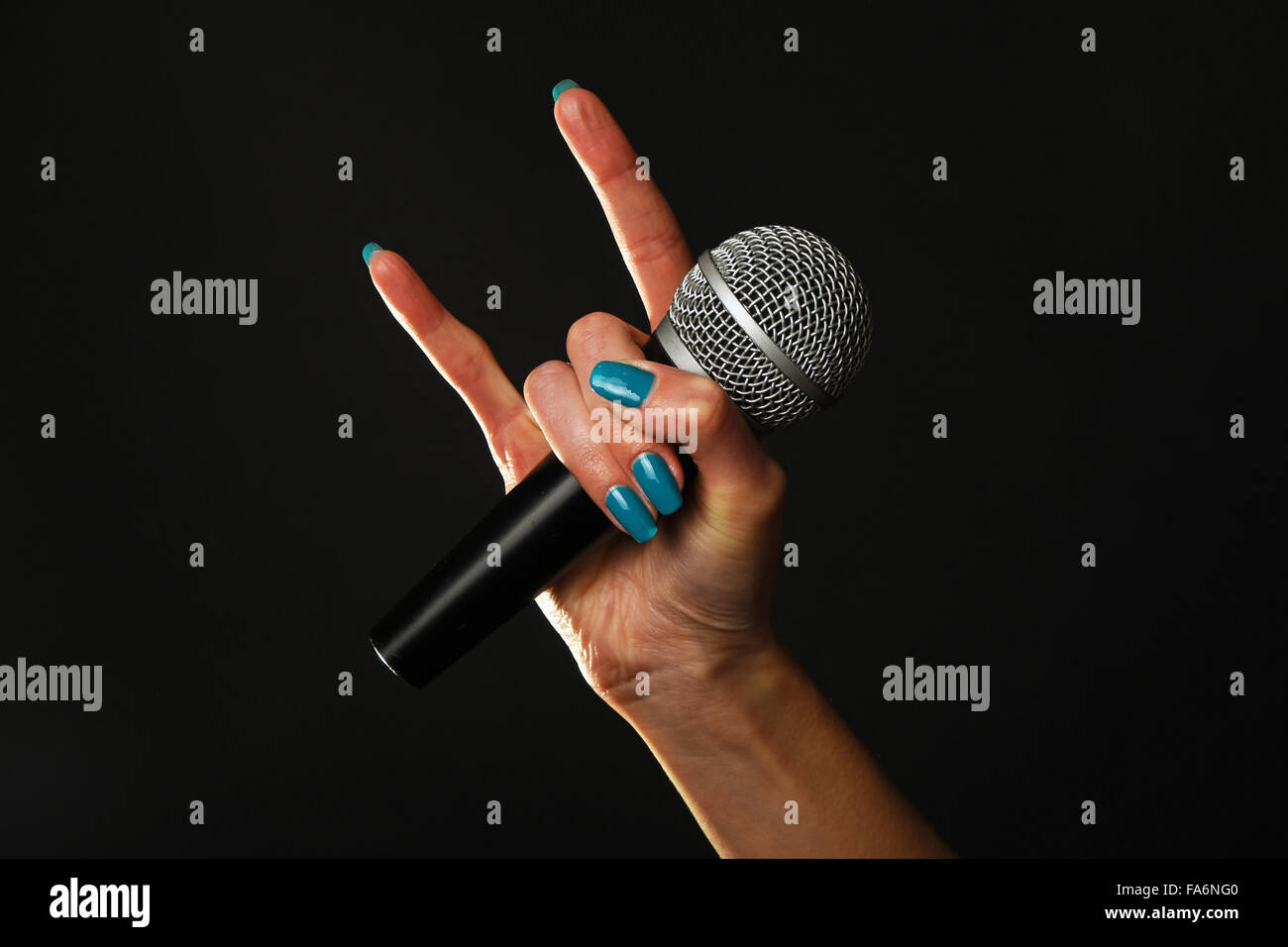Main femme bleu avec ongles tenant le microphone avec cornes de diable rock  metal sign isolé sur fond noir Photo Stock - Alamy