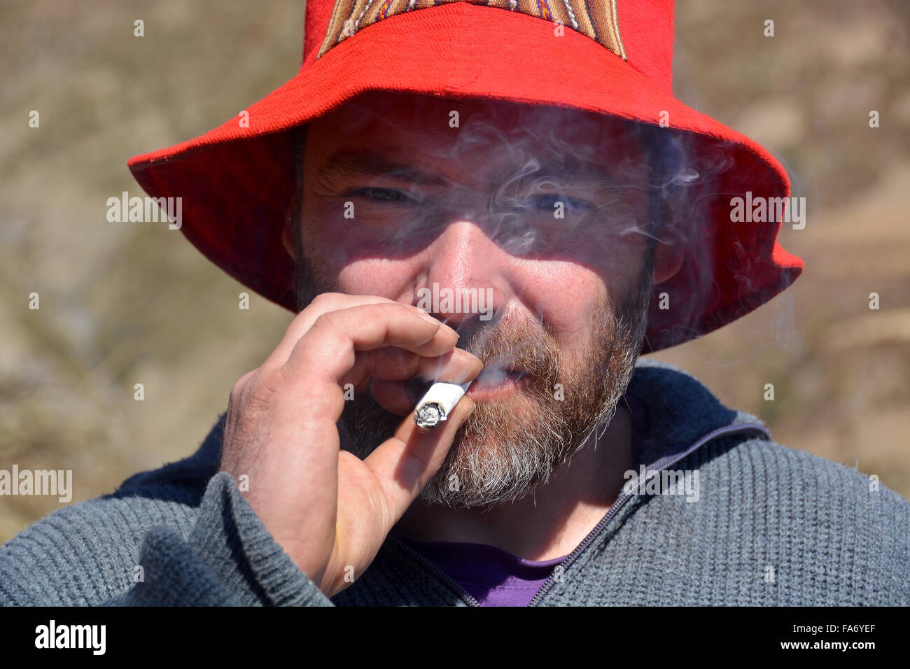 Homme avec Red Hat et beard cigarette Banque D'Images