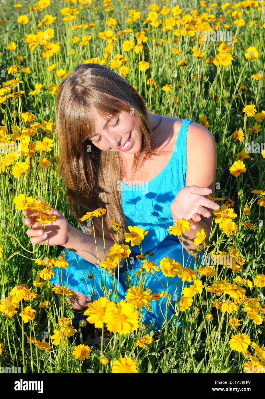 Portrait d'une adolescente parmi les fleurs jaunes Banque D'Images