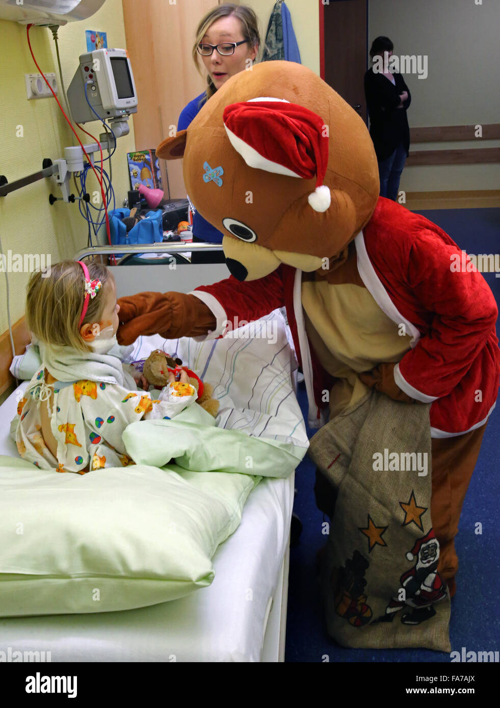 Rostock, Allemagne. Dec 22, 2015. Le Père Noël de l'hôpital de l'Ourson visites des trois ans (L) Finya qui doit rester à l'hôpital pour Noël à la suite d'une chirurgie dans le service de chirurgie pédiatrique de l'hôpital universitaire de Rostock, Allemagne, le 22 décembre 2015. Peu de patients sont sortis de l'hôpital chaque fois que possible, mais ceux qui doivent rester seront toujours voir le Père Noël. Photo : BERND WUESTNECK/dpa/Alamy Live News Banque D'Images