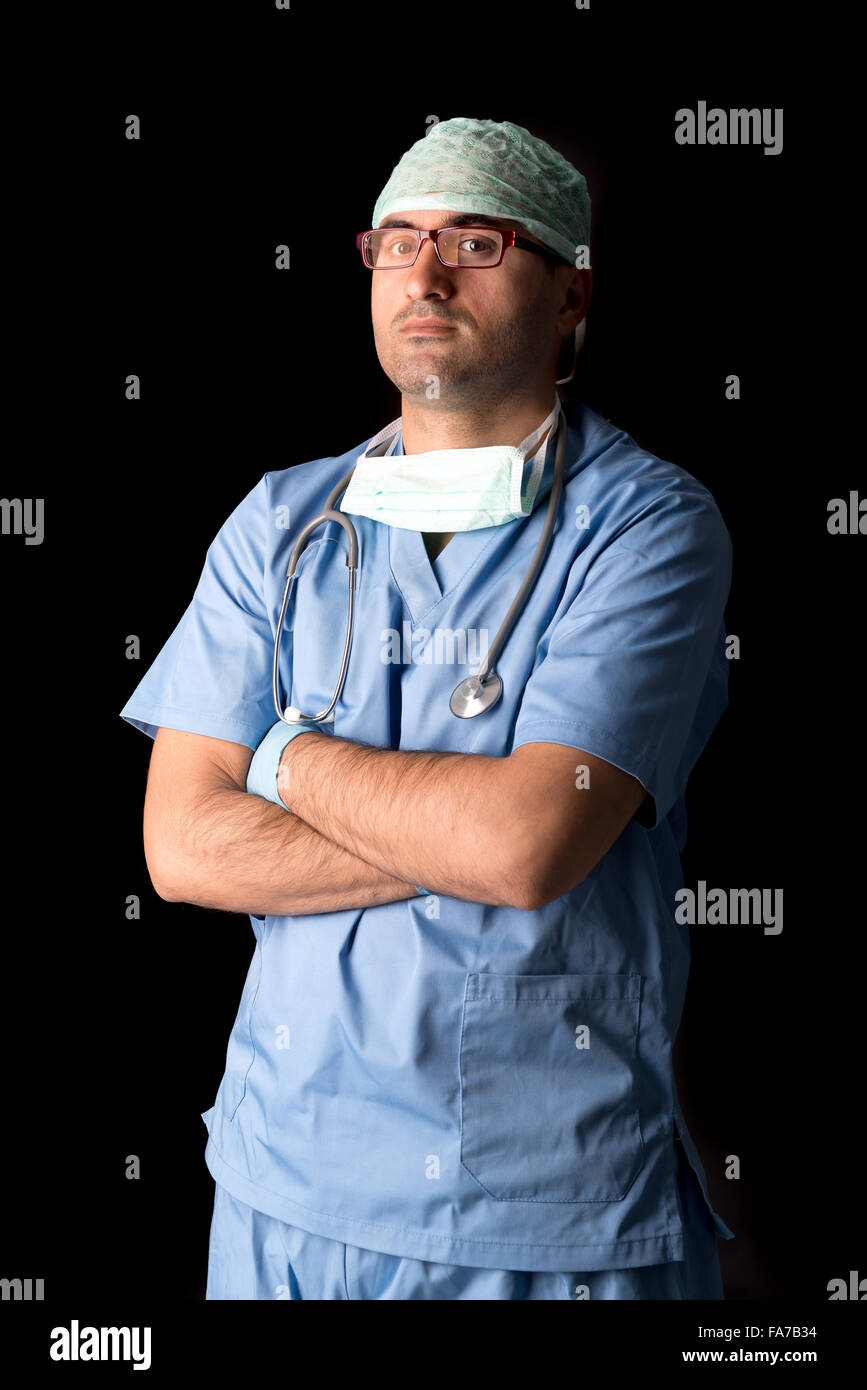 Médecin en uniforme posant isolé dans le noir Banque D'Images