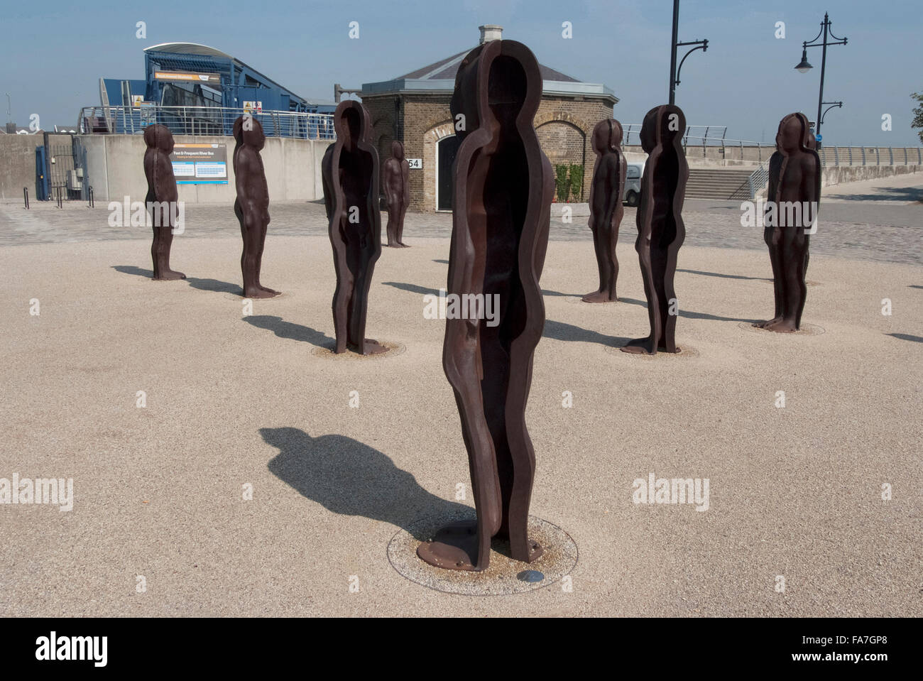 Assemblée générale, par Peter Burke, Woolwich Arsenal, à Londres. Statues debout dans un groupe dans un espace ouvert. Architecture moderne du parc olympique. Banque D'Images