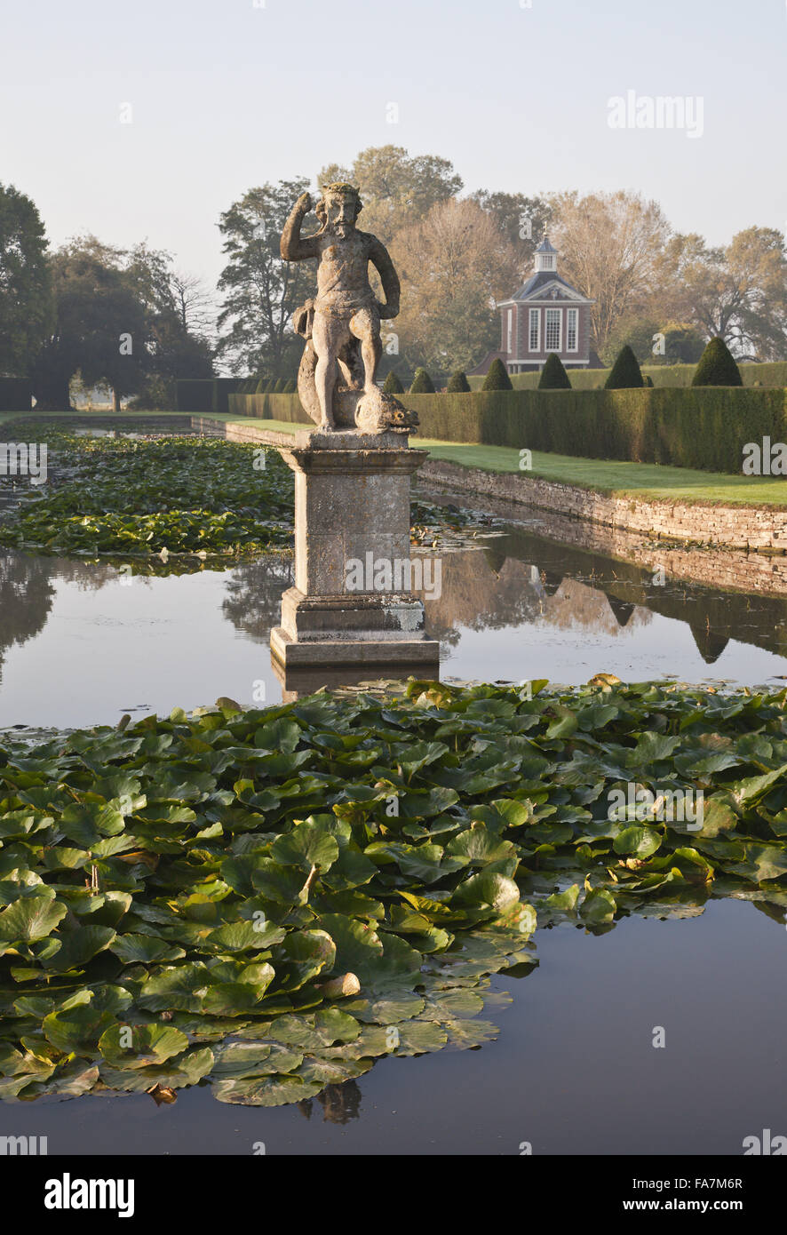 Vue sur le canal en forme de T, avec le milieu-c 17ème statue de Neptune, le jardin de la Cour à Westbury, Gloucestershire. Le Grand Pavilion (construite en 1702-3) peuvent être vus dans l'arrière-plan. Banque D'Images