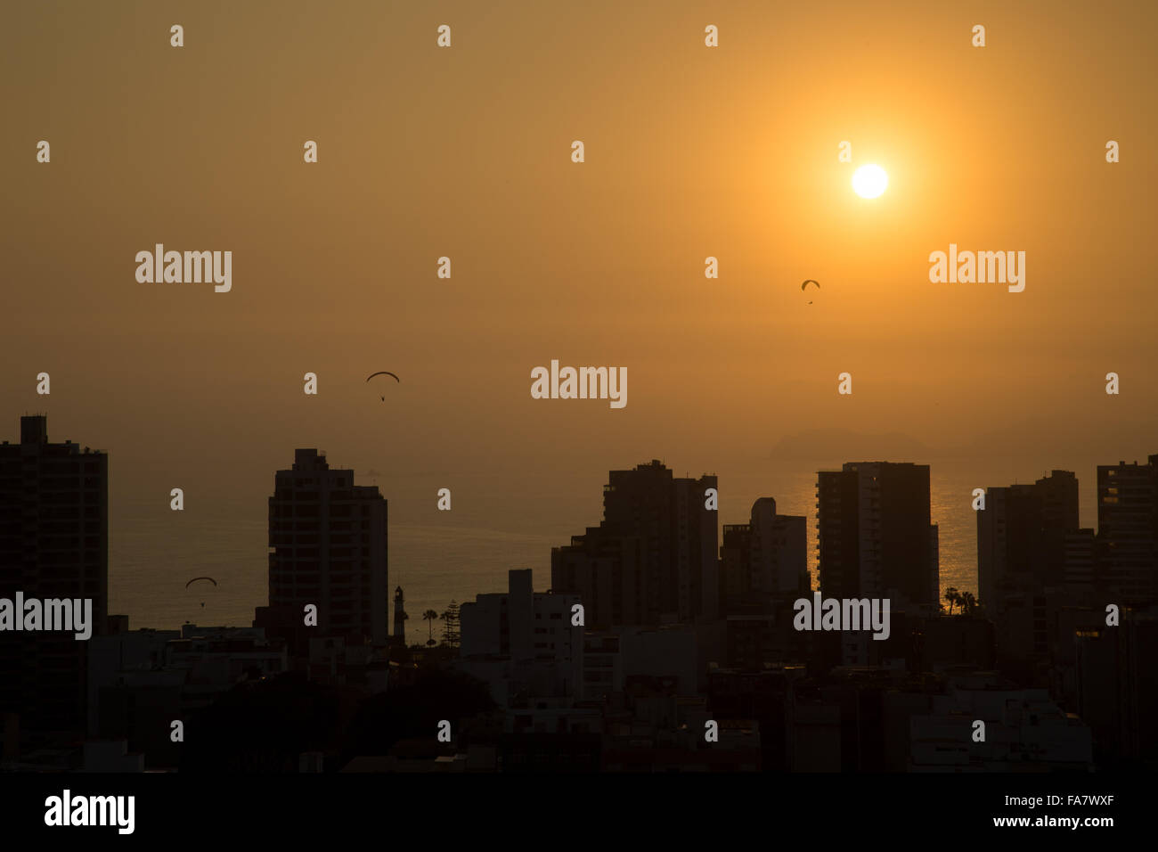 Photographie de parapentes pendant le coucher du soleil avec l'horizon du quartier Miraflores de Lima, Pérou. Banque D'Images