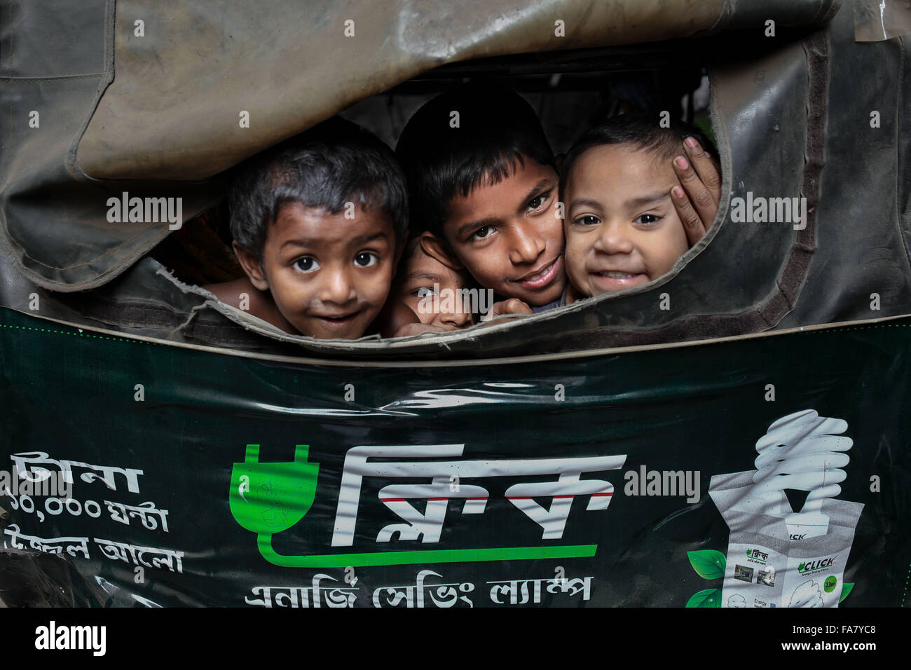 Dhaka, Bangladesh. Dec 23, 2015. Sourire par les enfants assis dans une casse auto rickshaw à Dhaka. © Mohammad Ponir Hossain/ZUMA/Alamy Fil Live News Banque D'Images