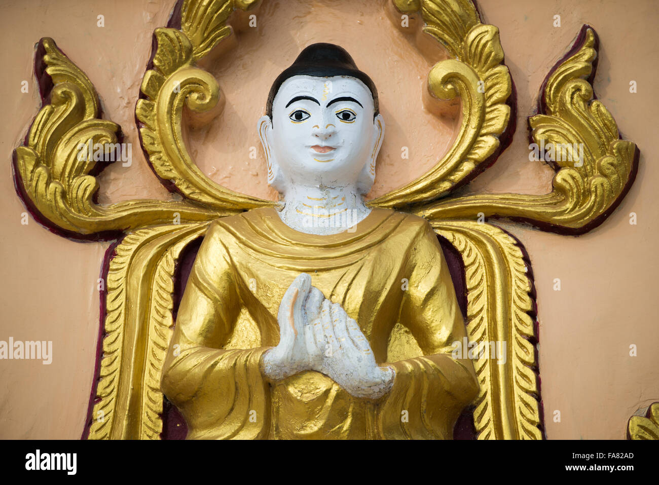 SAGAING, Myanmar — debout sur une colline à Sagaing, la pagode OoHminThoneSel (Oo Hmin Thone sel Pagoda) présente une longue alcôve courbée bordée de dizaines de statues du Bouddha. Après de récentes rénovations et améliorations en cours rendues possibles par des donateurs, la pagode est richement décorée avec des mosaïques de carreaux colorés et de la peinture fraîche et brillante. Banque D'Images