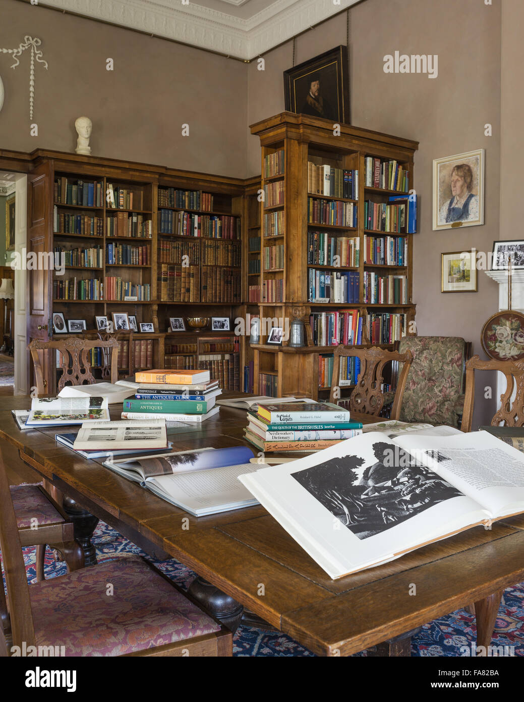 Les livres qui peuvent être consultés par les visiteurs sont disposés sur une table dans la bibliothèque de Killerton, Devon. Cette chambre a été transformée en bibliothèque au cours de l'époque édouardienne. Banque D'Images