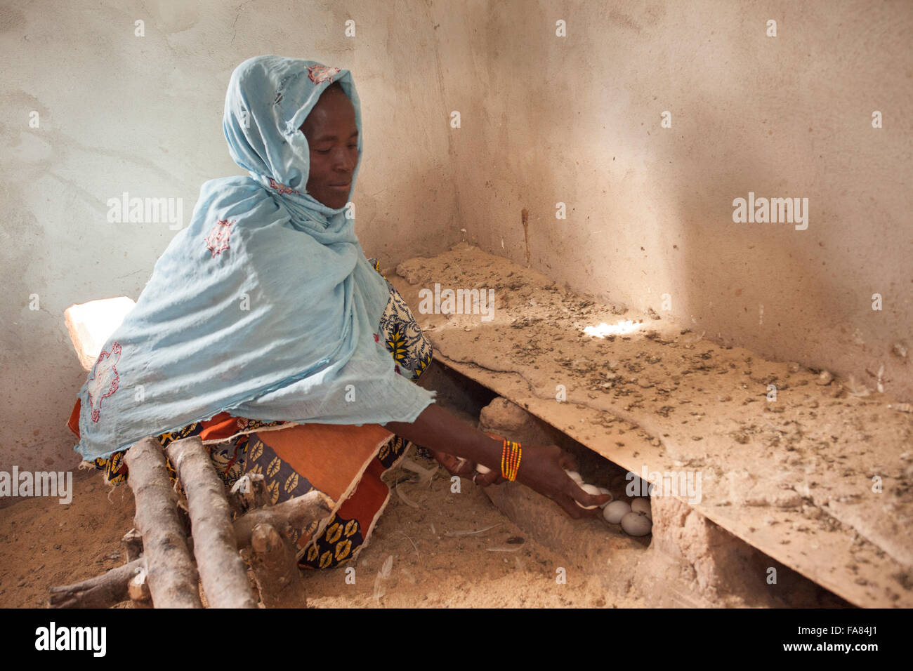 Une femme est titulaire d'un des oeufs frais pondus par ses poules à Tengréla, village du Burkina Faso. Banque D'Images