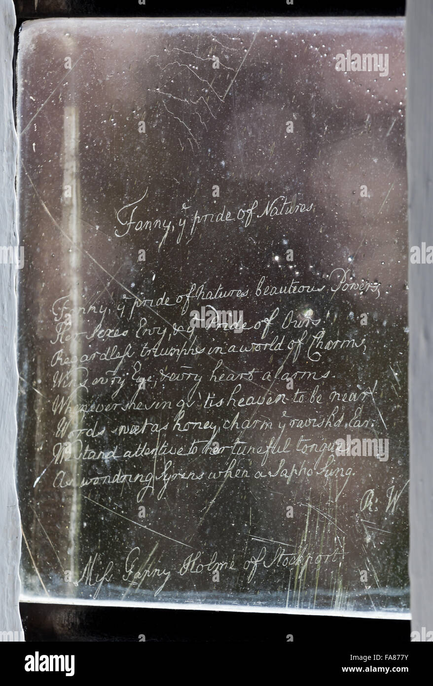 Un poème de rayures sur la fenêtre de la bibliothèque de Eyam Hall et centre d'Artisanat, Derbyshire. Eyam Hall est un exemple d'un manoir Jacobin pierre meulière, situé dans un jardin clos. Banque D'Images