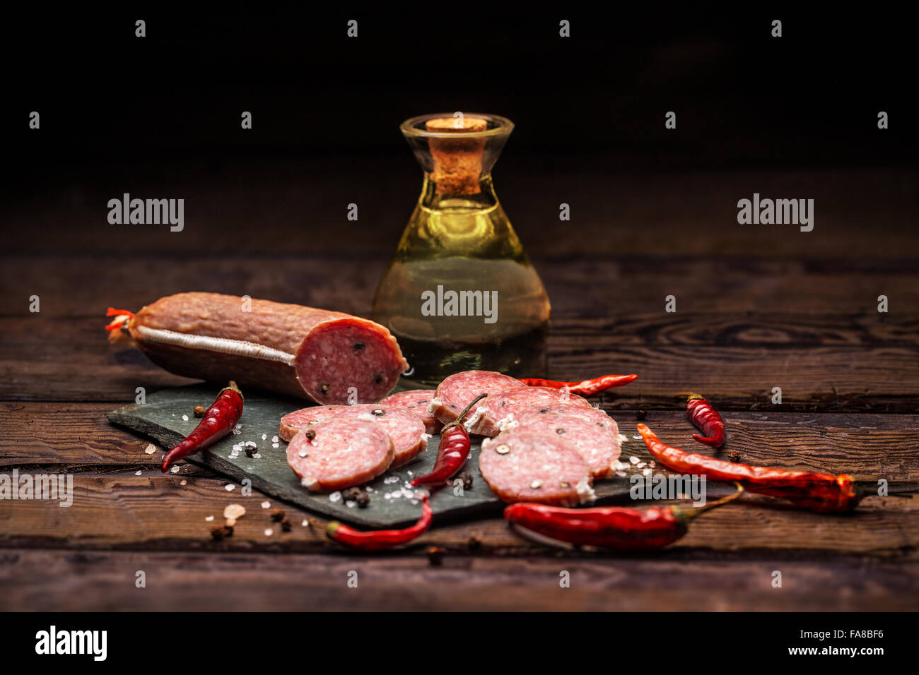 Le salami sur ardoise à découper sur la table en bois Banque D'Images