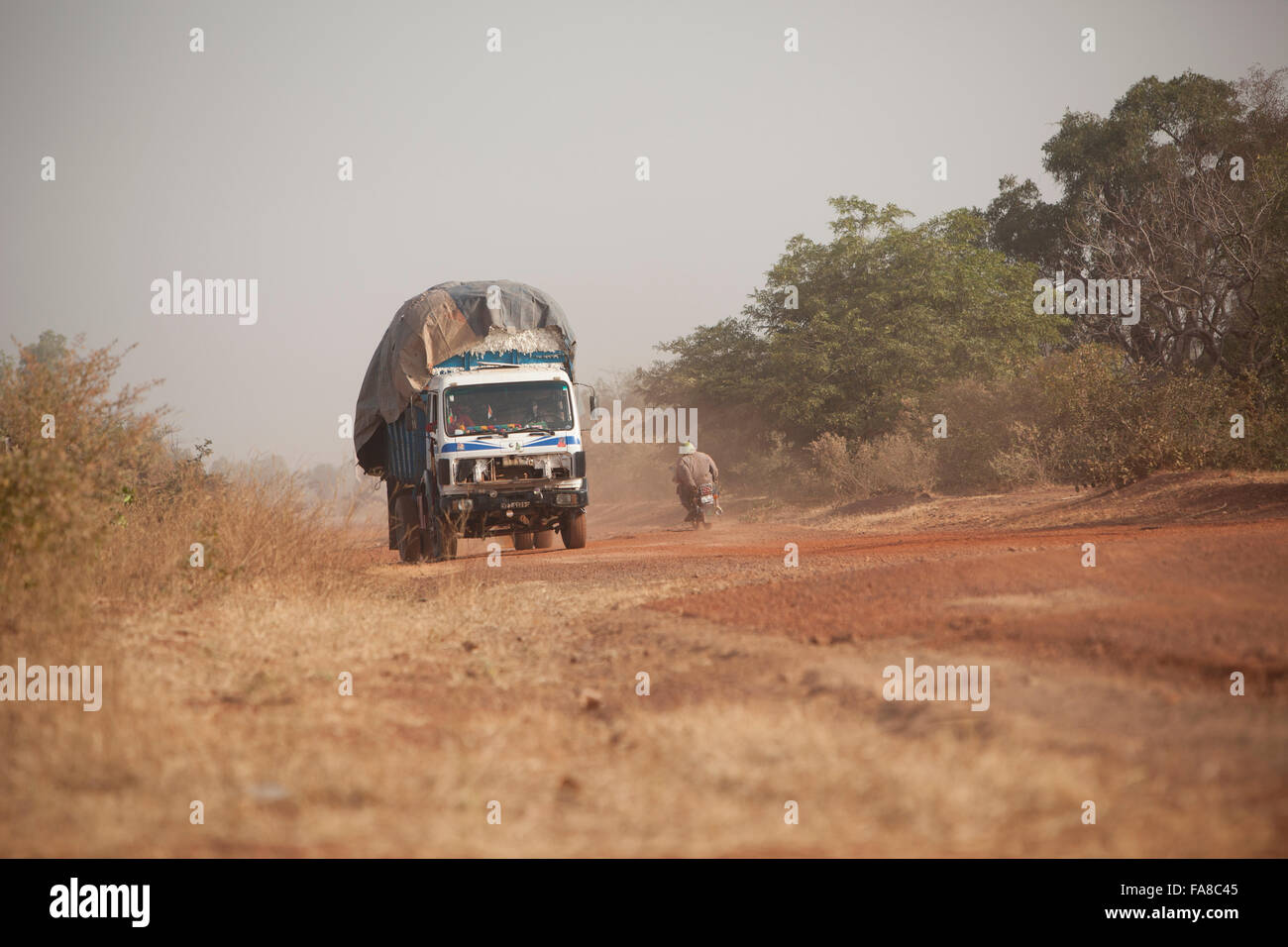 Un camion surchargé traverse une route poussiéreuse à Kouka, Ministère du Burkina Faso. Banque D'Images