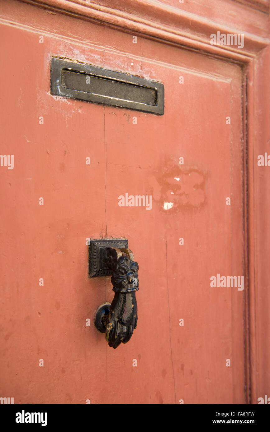 Un vieux doorknocker sur une porte orange colorés dans le panier près de Marseille, France. Banque D'Images