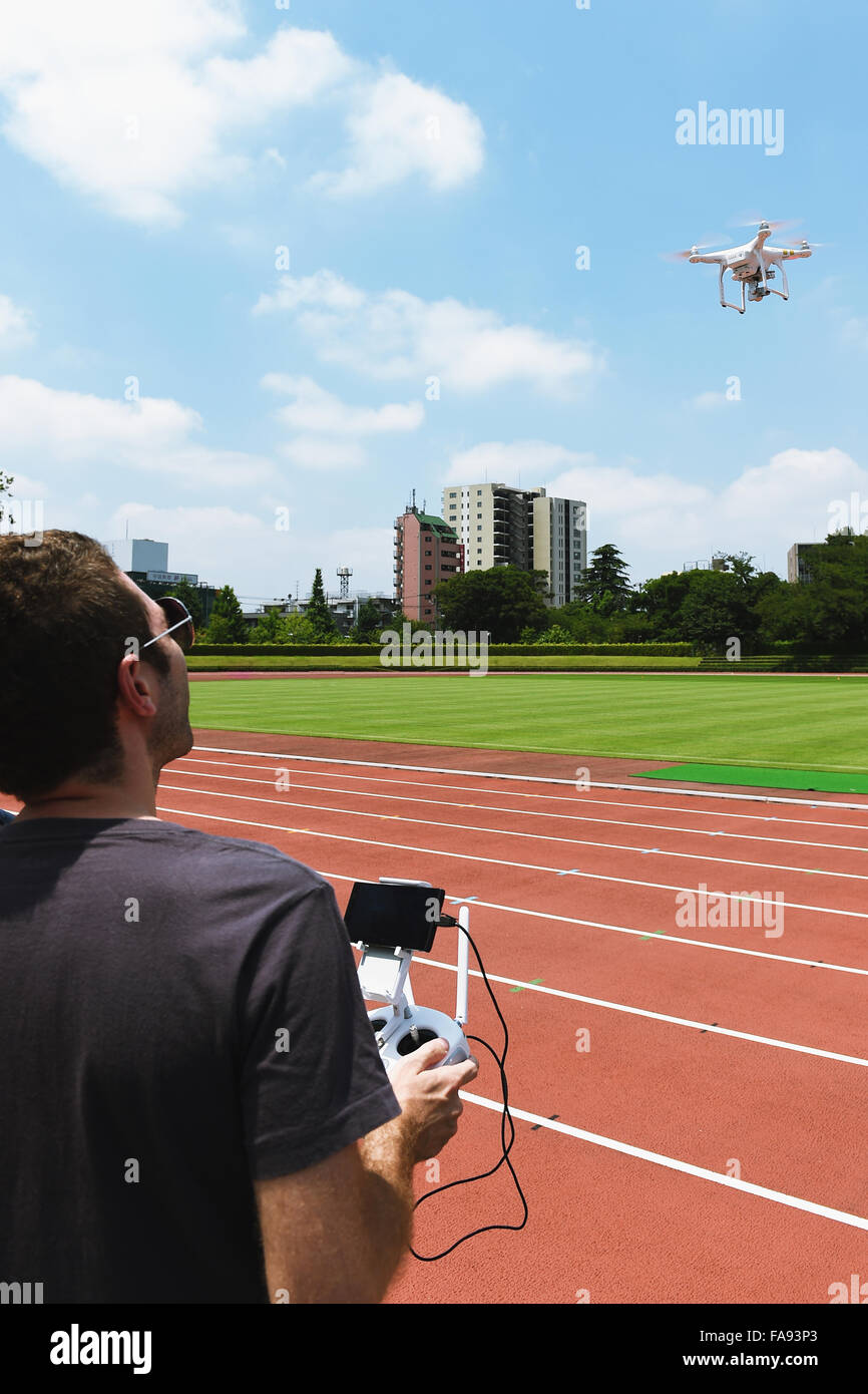 Caucasian man flying Quadcopter dans un stade Banque D'Images