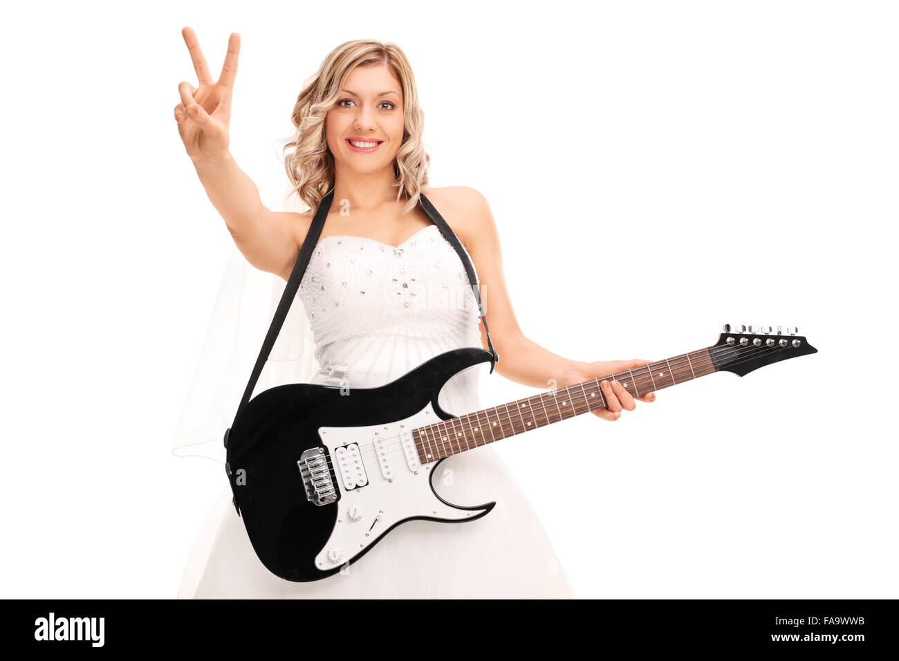 Jeune femme jouant de la guitare électrique et de faire un signe de la paix avec sa main isolé sur fond blanc Banque D'Images
