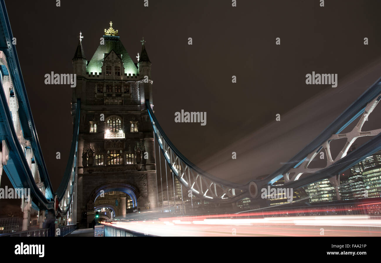 London Tower Bridge, UK, de nuit avec des voitures et bus en laissant des traces de lumière colorée. Banque D'Images