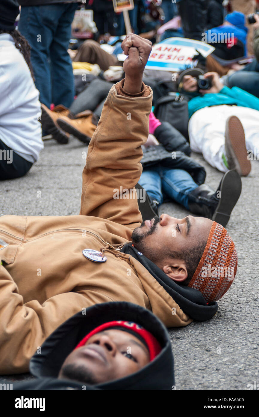 Chicago, USA. 24 décembre 2015. Des centaines de personnes se rassemblent à mars vers le bas de l'Avenue Michigan Magnificent Mile' commerçant sur la veille de Noël pour protester contre les allégations de camouflage de police liés à la mort d'Laquand McDonald par un policier de Chicago. Entouré de membres de la force de police de Chicago, des manifestants scandaient "16 coups et une dissimulation," et appelant à la maire de Chicago Rahm Emanuel de démissionner, sur ce qui a été décrit comme 'Black Christmas'. Crédit : Stephen Chung / Alamy Live News Banque D'Images