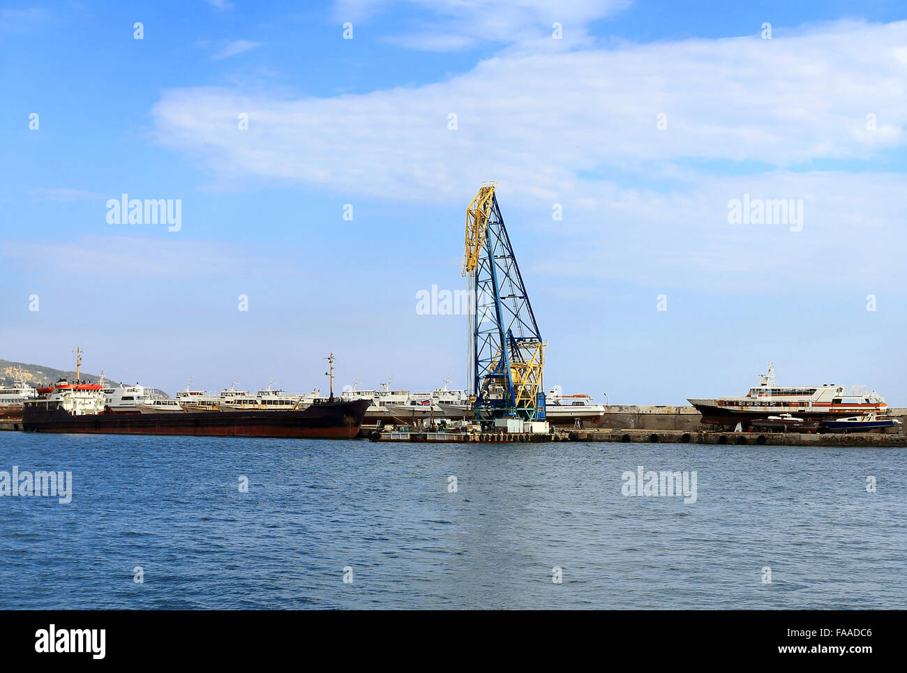 Port maritime de fret avec grue, vieux navires et équipements de manutention Banque D'Images