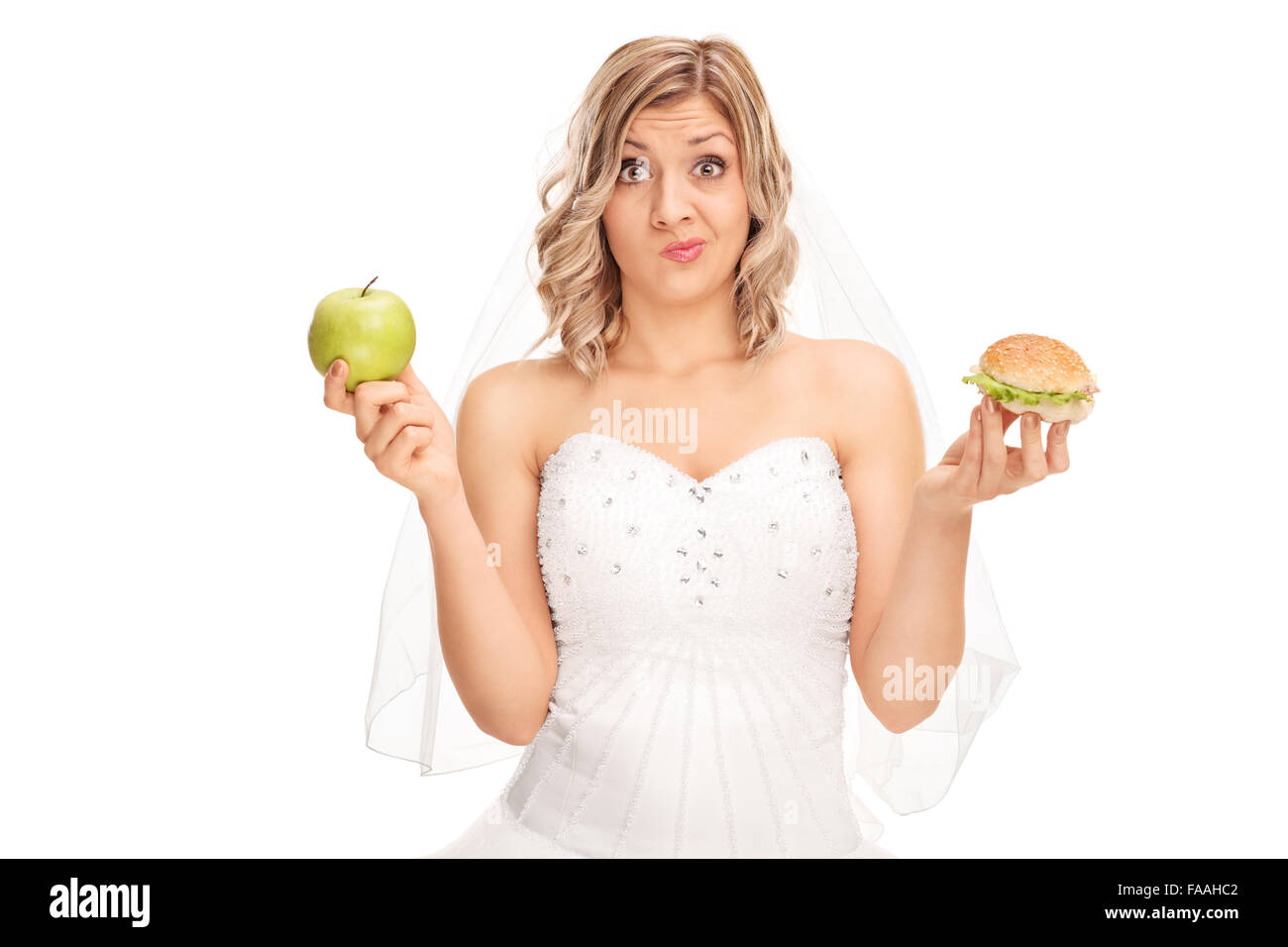 Jeune femme tenant une pomme dans une main et un hamburger dans l'autre isolé sur fond blanc Banque D'Images