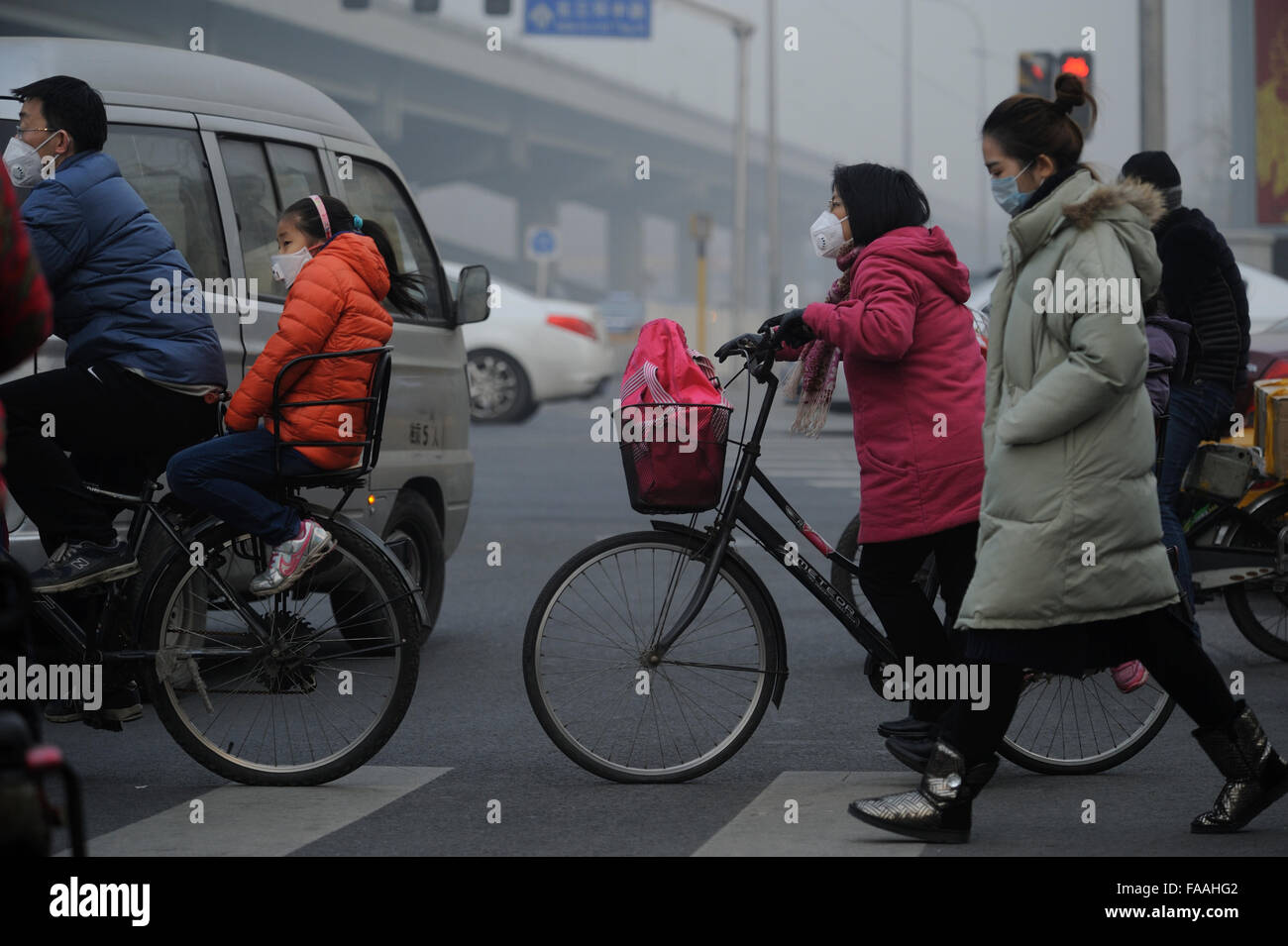 Les gens portent des masques qu'un épais brouillard de pollution de l'air des enveloppes Beijing, Chine. 25-Déc-2015 Banque D'Images
