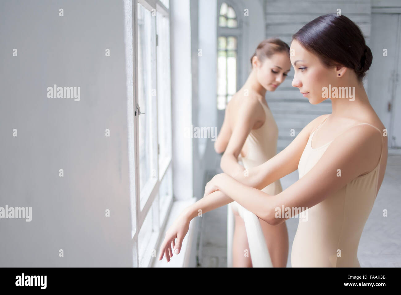 Les deux danseurs de ballet classique posing at barre Banque D'Images