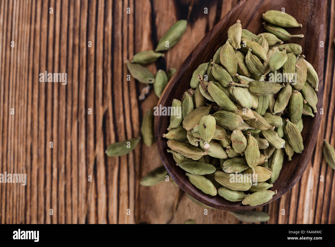 Les graines de cardamome sur fond de bois (gros plan) Banque D'Images