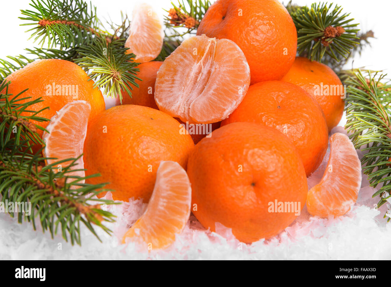 Mandarines sur la neige avec des branches de sapin. Banque D'Images