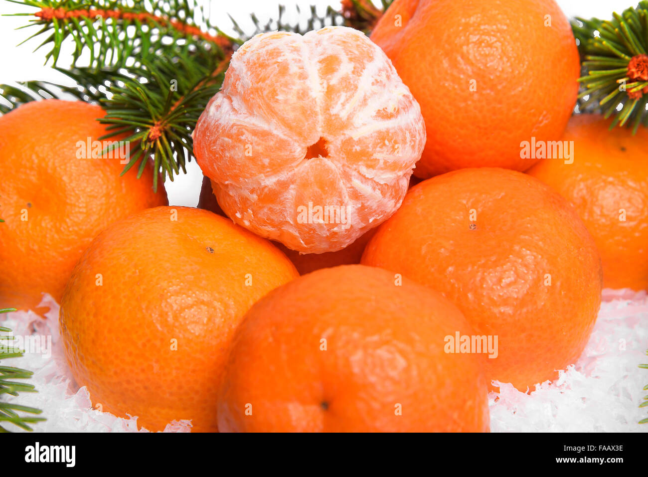 Mandarines sur la neige avec des branches de sapin. Banque D'Images
