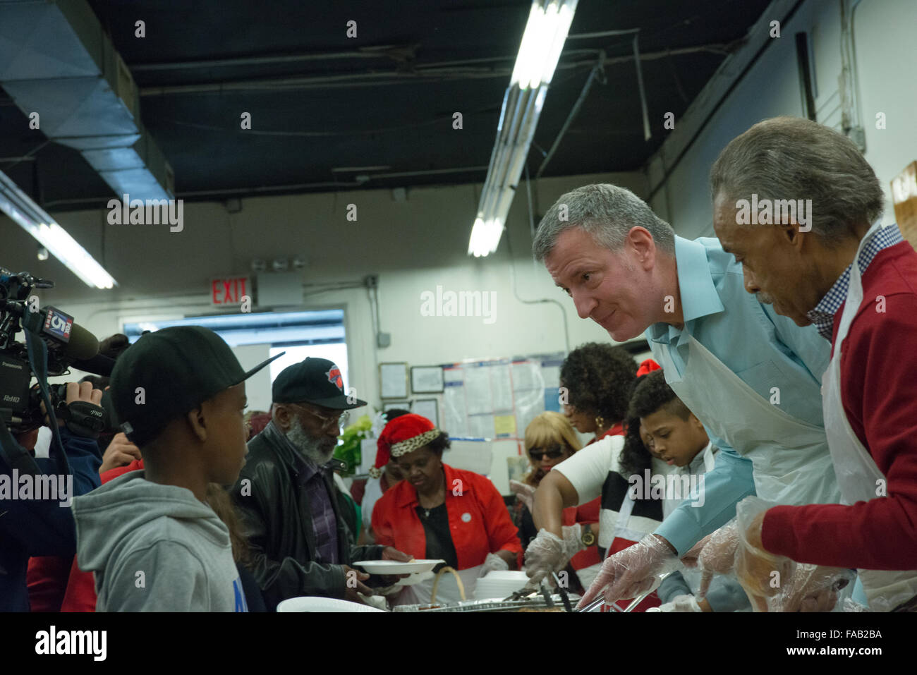 New York, États-Unis. Dec 25, 2015. Maire de Blasio et le Révérend Sharpton servent de nourriture à la NAN repas de vacances. Maire de la ville de New York, Bill De Blasio et sa fille Chiara a rejoint le révérend Al Sharpton à la maison de la Justice, réseau d'Action National (NAN) siège et centre communautaire de West 145e Rue à Harlem, à participer au repas de fête annuelle du NAN et des jouets pour les plus démunis. © Albin Lohr-Jones/Pacific Press/Alamy Live News Banque D'Images