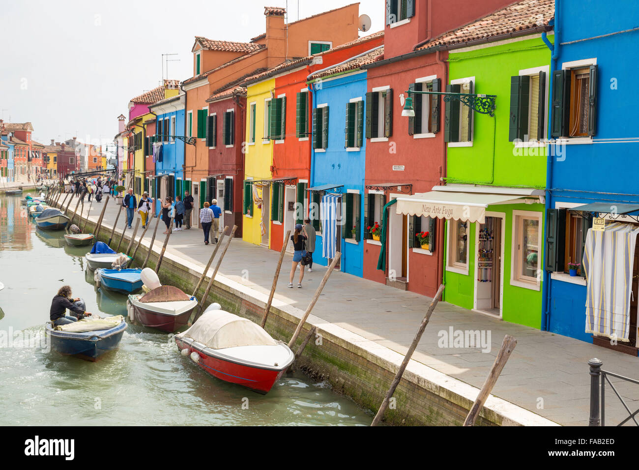 Les touristes marcher sur ses rues colorées de Burano ville avec des bateaux et des maisons traditionnelles près de lagoon Banque D'Images