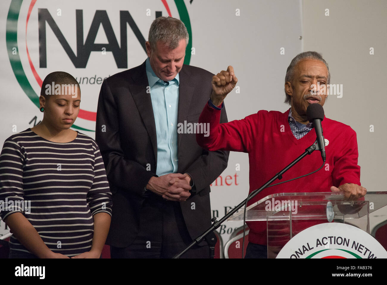 New York, États-Unis. Dec 25, 2015. Chiara et Bill De Blasio (gauche) baissent la tête comme le révérend Al Sharpton (à droite) offre une bénédiction avant de servir le repas de vacances. Maire de la ville de New York, Bill De Blasio et sa fille Chiara a rejoint le révérend Al Sharpton à la maison de la Justice, réseau d'Action National (NAN) siège et centre communautaire de West 145e Rue à Harlem, à participer au repas de fête annuelle du NAN et des jouets pour les plus démunis. © Albin Lohr-Jones/Pacific Press/Alamy Live News Banque D'Images