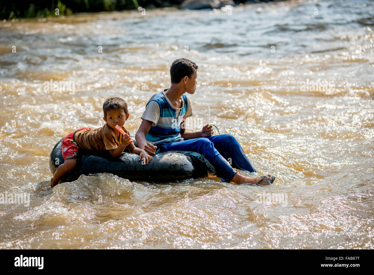 Enfants flottant sur les eaux rapides avec tube intérieur du pneu. Banque D'Images