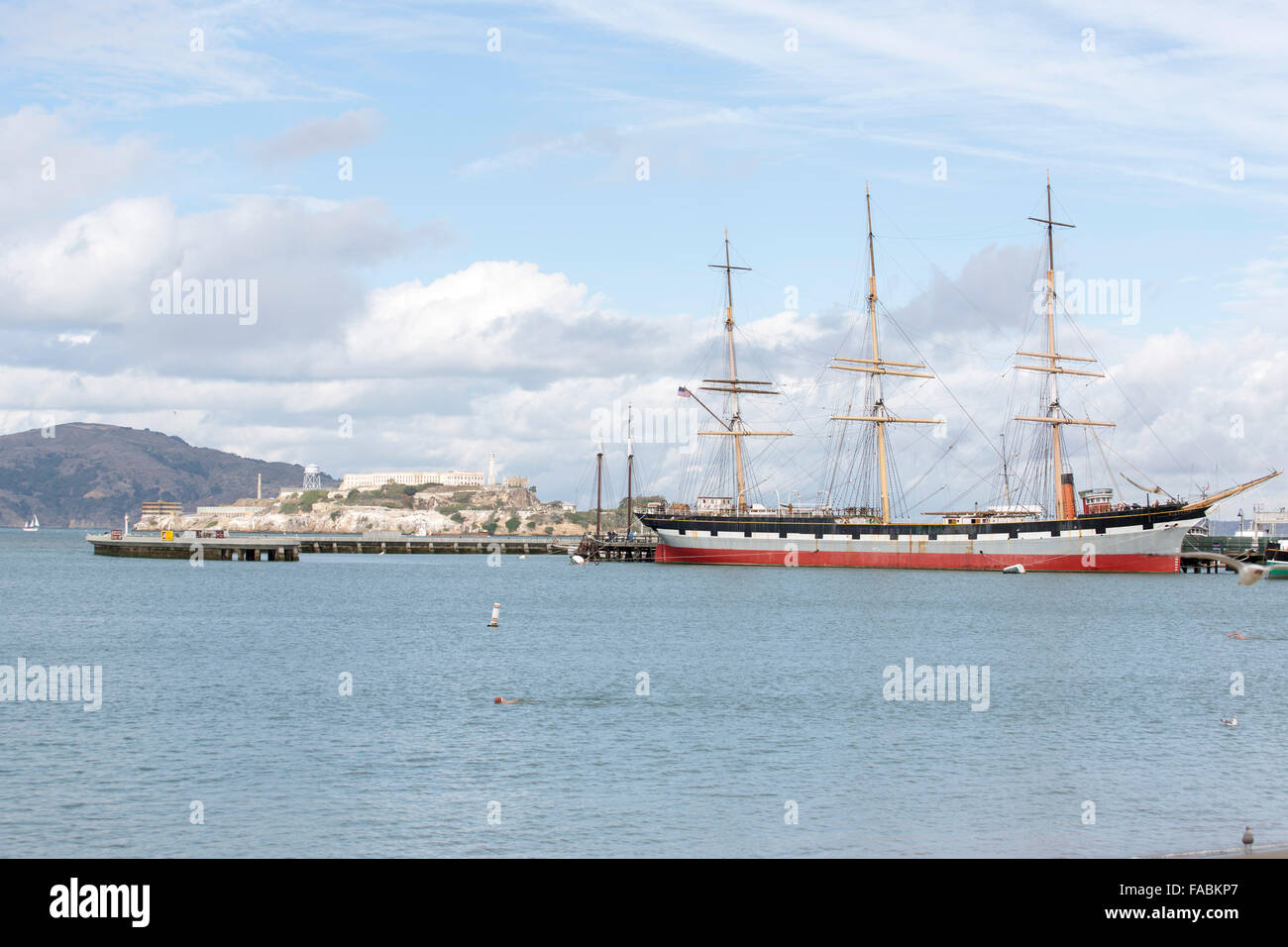 Le bateau à voile du musée Balclutha amarré à l'embarcadère 41 de la baie de San Francisco, Californie, États-Unis, avec l'île d'Alcatraz derrière Banque D'Images