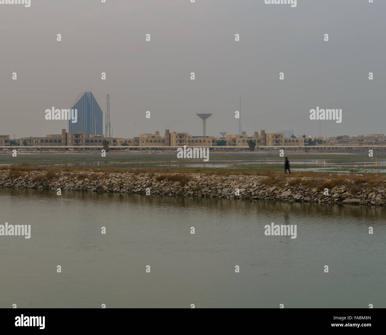 Homme marchant par boueux derrière l'Université de Koweït, Koweït Banque D'Images