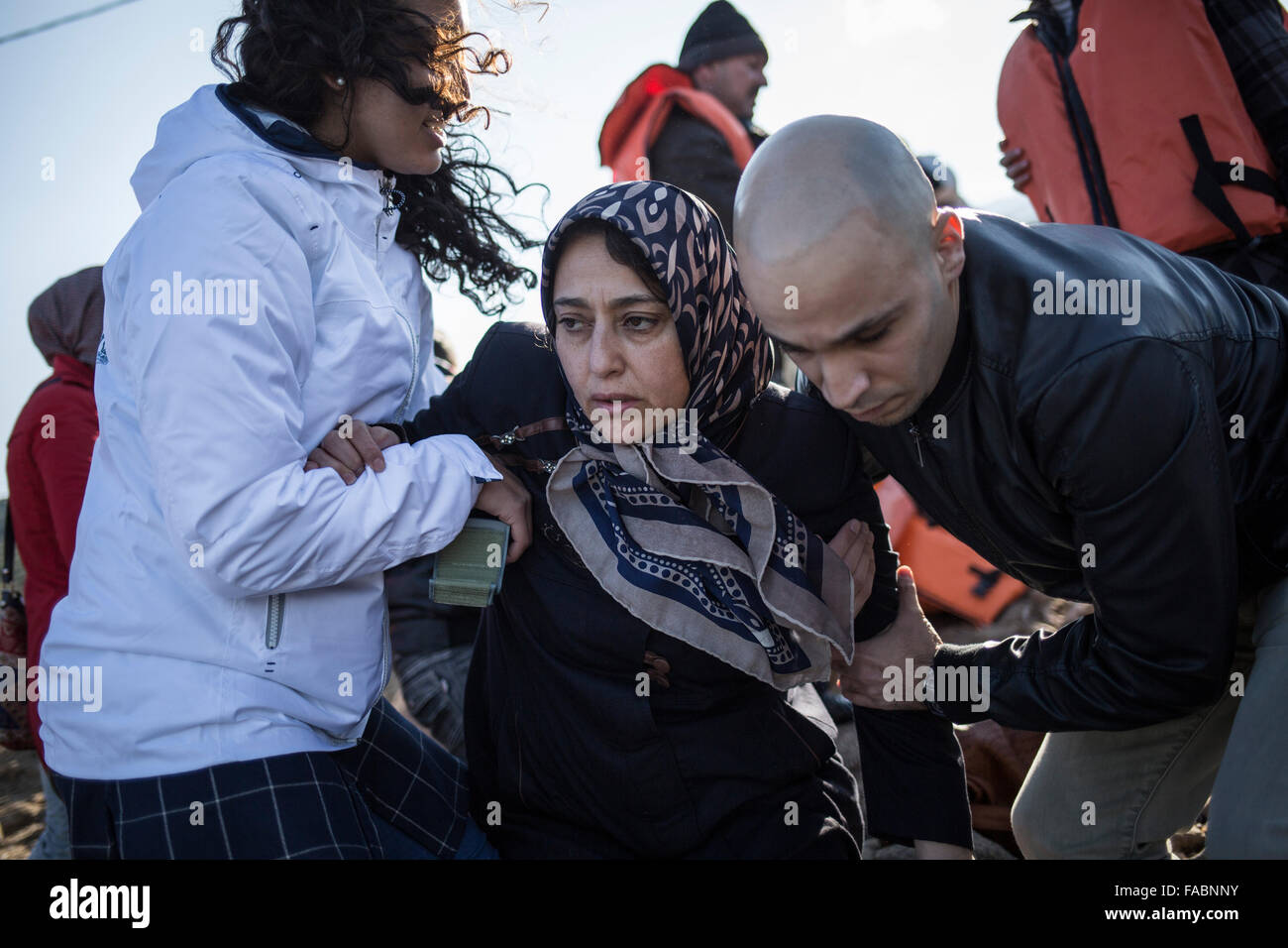 L'île de Lesvos, Grèce. Dec 26, 2015. Une femme afghane reçoit l'aide de bénévoles sur un rivage quelques minutes après son arrivée avec d'autres réfugiés et migrants dans un canot en caoutchouc voile venant de la côte turque à Skala Sikamineas sur l'île de Lesvos, Grèce, 26 décembre 2015. Photo : Baltagiannis Socrates/dpa/Alamy Live News Banque D'Images