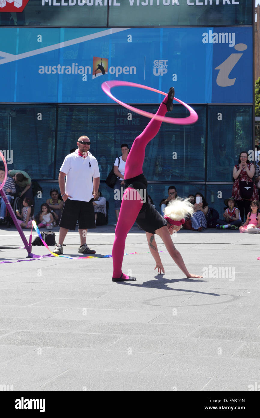 Artiste de rue montrant une performance hula-hoop sur Federation Square à Melbourne, Victoria, Australie, sur une journée ensoleillée. Banque D'Images