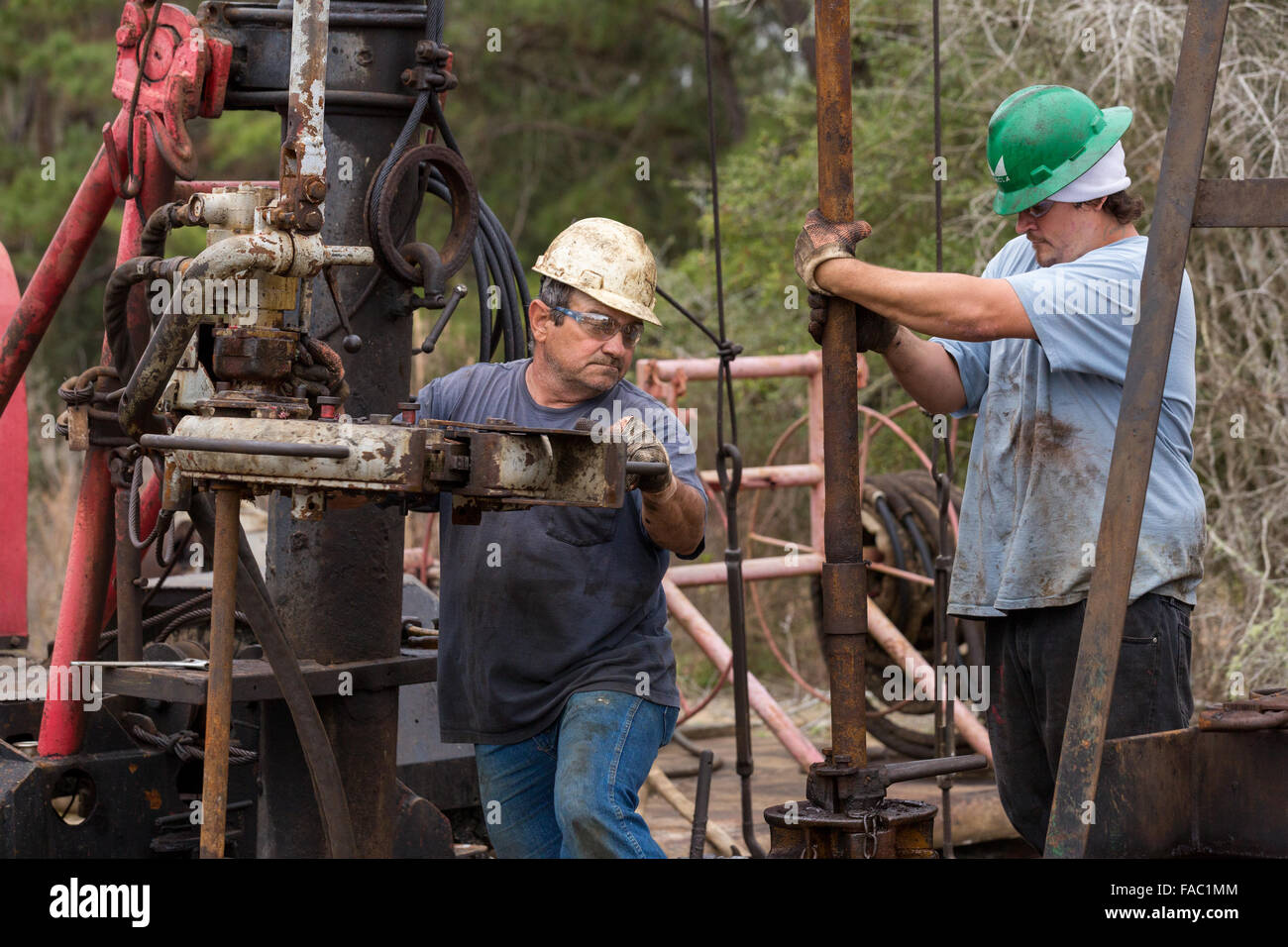 Les travailleurs du pétrole couler à l'aide d'un derrick de forage pour le pétrole brut dans Evangeline, Louisiane. Les champs de pétrole ont été les premiers puits en Louisiane. Banque D'Images