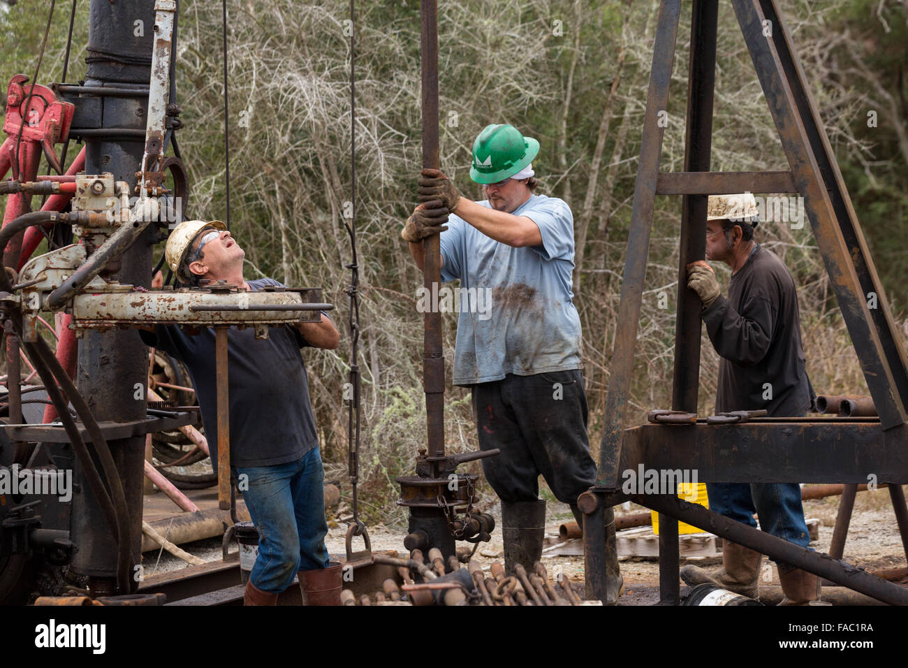Les travailleurs du pétrole couler à l'aide d'un derrick de forage pour le pétrole brut dans Evangeline, Louisiane. Les champs de pétrole ont été les premiers puits en Louisiane. Banque D'Images