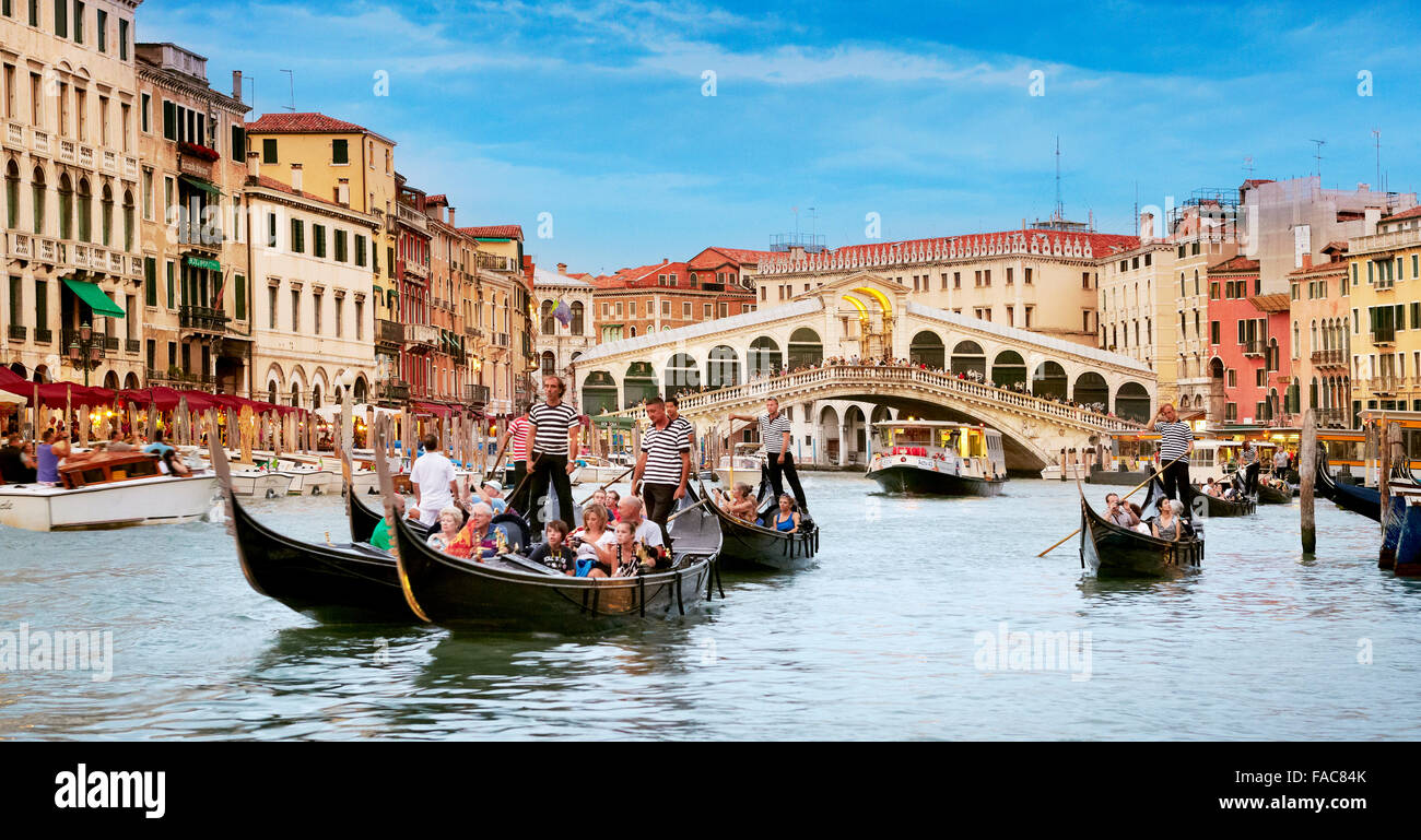 Les touristes en gondole explorer Grand Canal, le Pont du Rialto, dans l'arrière-plan, Venise, Italie Banque D'Images