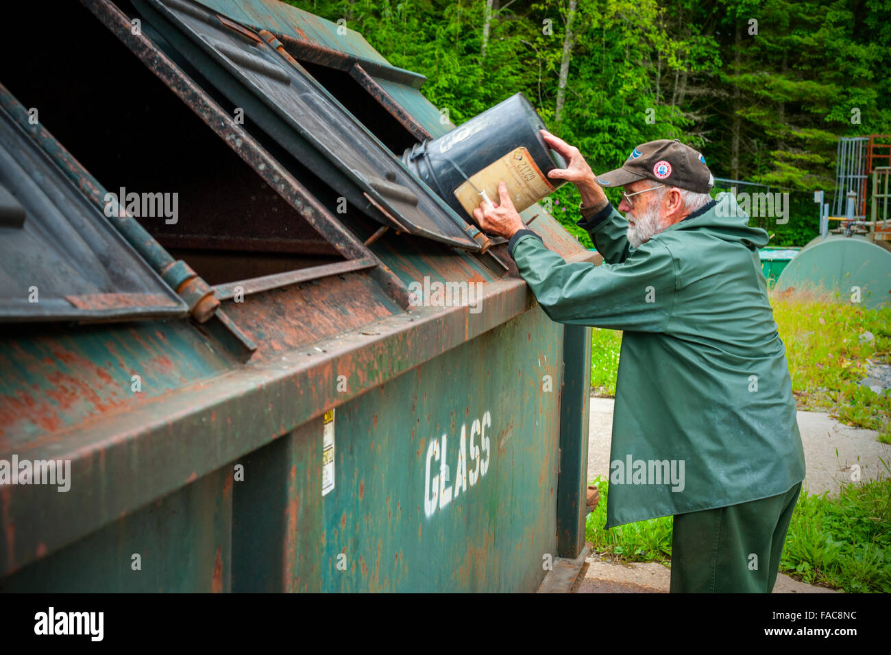Ce vieux gentleman affichant une citoyenneté fine et puissante au bac de recyclage de verre à Sitka, Alaska, États-Unis Banque D'Images